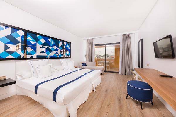 Doppelzimmer im AluaSoul Costa Adeje Hotel mit zwei Betten, moderner Einrichtung und Stadtblick.