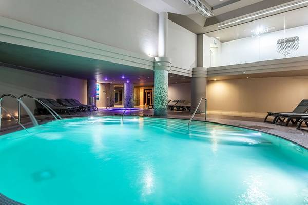 Innenpool im AluaSoul Costa Adeje Hotel mit blauem Wasser und Lounge-Bereich.