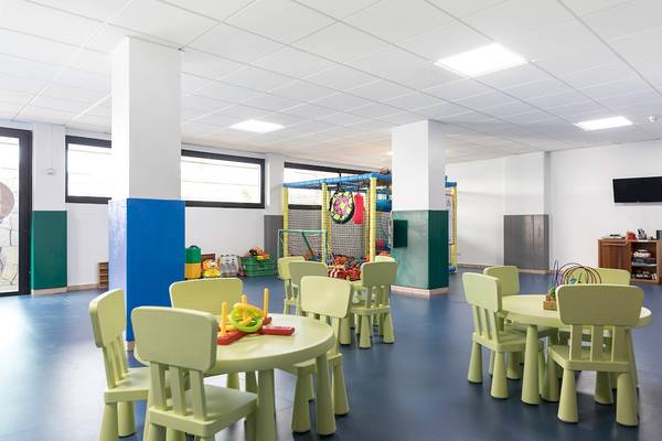 Kinderspielbereich im AluaSoul Costa Adeje Hotel mit grünen Tischen und Stühlen.