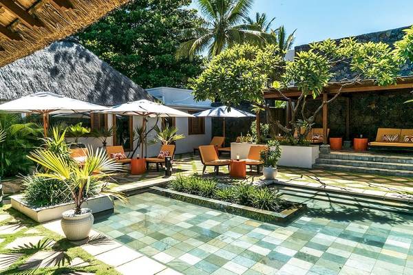 Außenbereich des Constance Belle Mare Plage Hotels mit Garten, Sitzbereichen und Pool