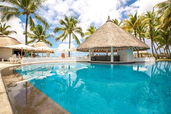 Poolbar im Constance Belle Mare Plage Hotel mit umliegenden Palmen und Sonnenschirmen