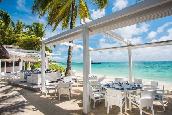 Außenterrasse des Constance Belle Mare Plage Hotels mit Blick auf den Strand und das Meer.