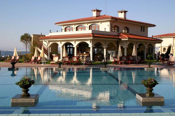 Außenbereich des Helena Sands Hotels mit Swimmingpool, Sonnenliegen und Terrassenmöbeln.