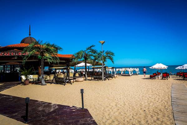 Helena Sands Hotel Strand mit Sonnenschirmen, Liegen und Palmen