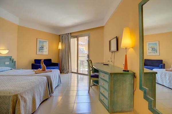 Doppelzimmer im SBH Costa Calma Beach Resort mit zwei Betten, einem Schreibtisch und einem Spiegel.