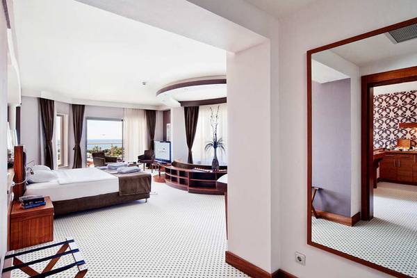 Suite-Zimmer im Sueno Hotels Beach Side mit großem Bett, Fernseher und Meerblick.