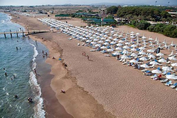 Luftaufnahme des Sueno Hotels Beach Side mit vielen Sonnenschirmen und Liegen am Strand