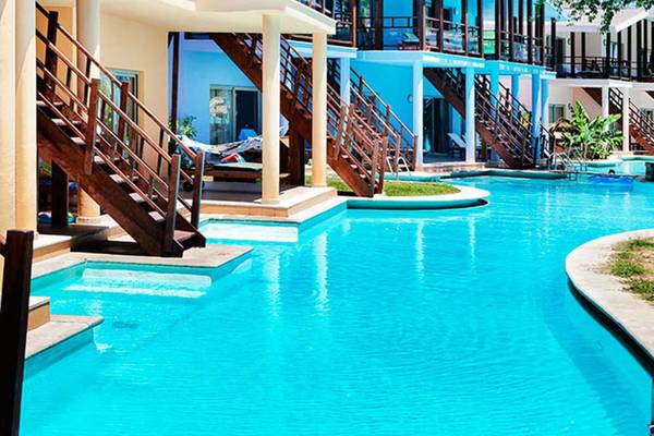 Außenansicht des Sueno Hotels Beach Side mit blauem Pool und Holztreppen.