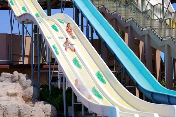 Kinder und ein Mann rutschen auf Wasserrutschen im Sueno Hotels Beach Side