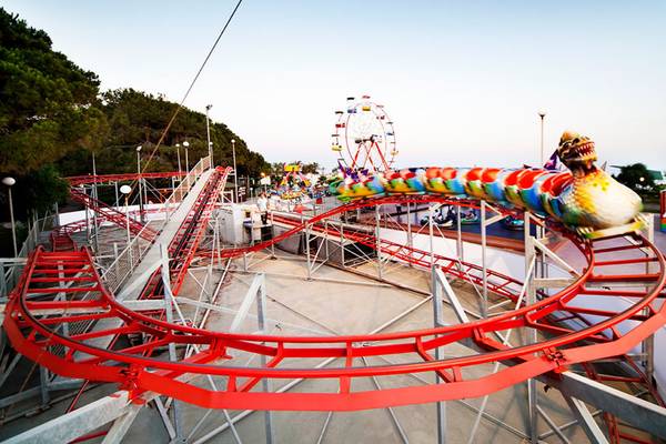 Achterbahn im Freizeitpark mit Sueno Hotels Beach Side im Hintergrund.