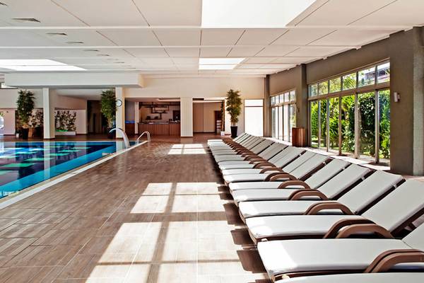 Innenpoolbereich mit Loungeliegen im Sueno Hotels Beach Side
