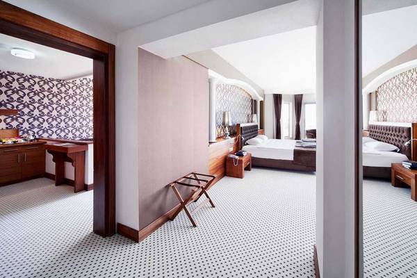 Suite-Zimmer im Sueno Hotels Beach Side mit zwei Betten, Ankleidebereich und Badezimmer.
