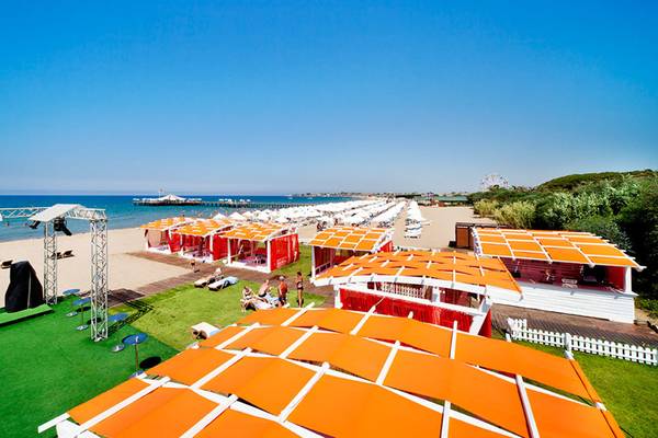 Luftaufnahme von Sueno Hotels Beach Side mit roten und orangefarbenen Cabanas am Strand