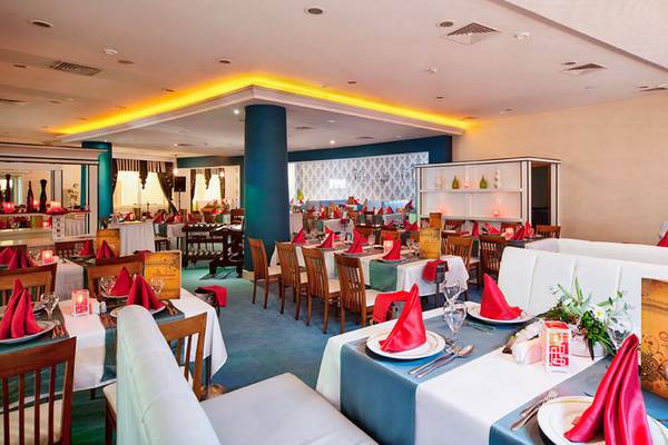 Innenansicht des Restaurants im Sueno Hotels Beach Side mit gedeckten Tischen und Stühlen.
