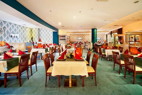 Innenansicht des Restaurants im Sueno Hotels Beach Side mit gedeckten Tischen und Stühlen.