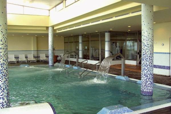 Innenpool des SBH Hotel Costa Calma Palace mit Wasserfällen und Lounge-Stuhlbereich.