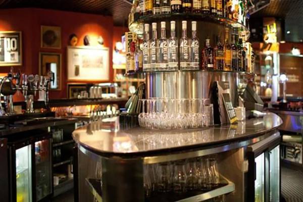 Die Bar im Manzil Downtown by Vida Hotel in Dubai mit verschiedenen Flaschen und Gläsern.