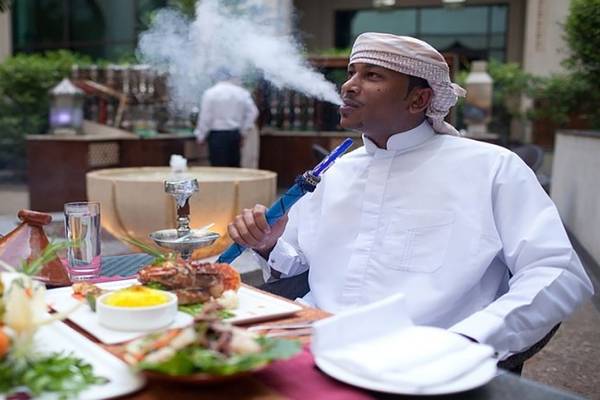 Mann mit Shisha im Restaurant Manzil Downtown in Dubai
