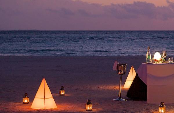 Meeru Island Resort & Spa Strand Abendessen mit einem Paar, das sich ansieht, während sie auf der Insel stehen.