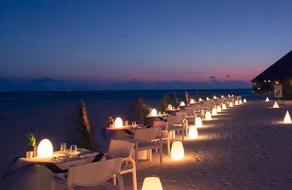 Meeru Island Resort & Spa - Abendessen auf dem Strand mit leuchtenden Dekorationen.