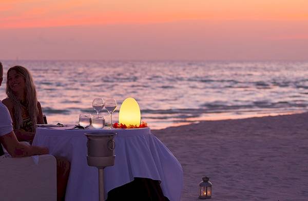 Dinner am Strand im Meeru Island Resort & Spa bei Sonnenuntergang.