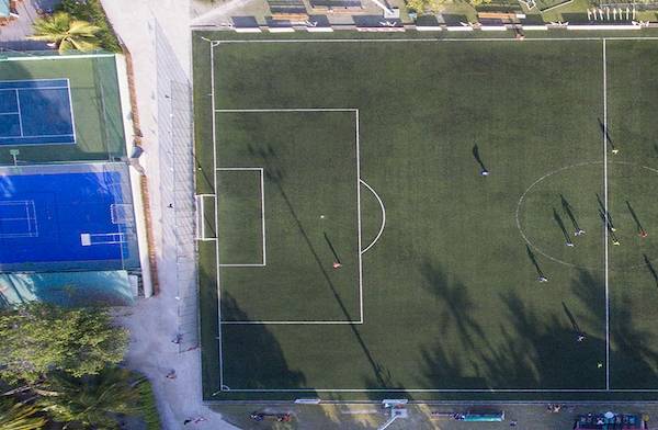 Luftaufnahme des Fußballplatzes im Meeru Island Resort & Spa mit Spielern und Trainingsaktivitäten