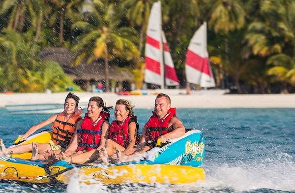 Gruppe auf Wassersportboot mit Meeru Island Resort & Spa im Hintergrund