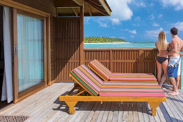 Paar auf dem Balkon des Meeru Island Resorts & Spa mit Blick auf das Meer