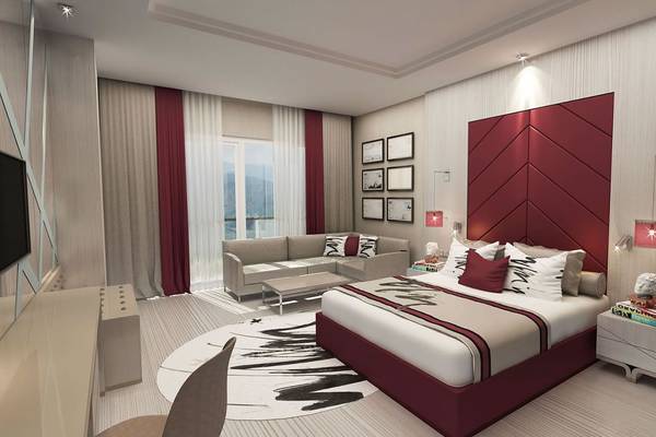 Designer Schlafzimmer im Delphin BE Grand Resort mit einem großen Bett, einem roten Kopfteil und einer gemütlichen Sitzecke.