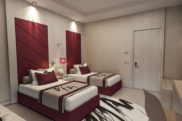 Doppelzimmer im Delphin BE Grand Resort mit zwei Betten, Nachttischen und Wandbeleuchtung.
