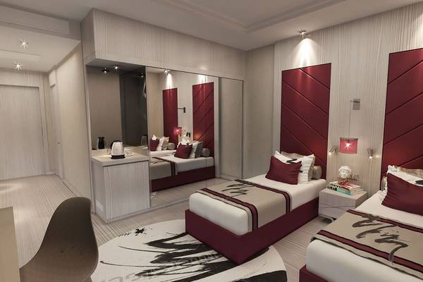 Doppelzimmer im Delphin BE Grand Resort mit zwei Betten, Nachttischen und einem Spiegel.