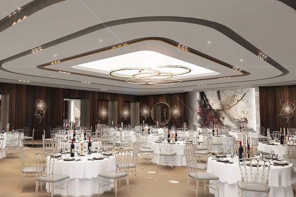 Bankettsaal des Delphin BE Grand Resort mit vielen gedeckten Tischen und einer großen zentralen Lichtinstallation.