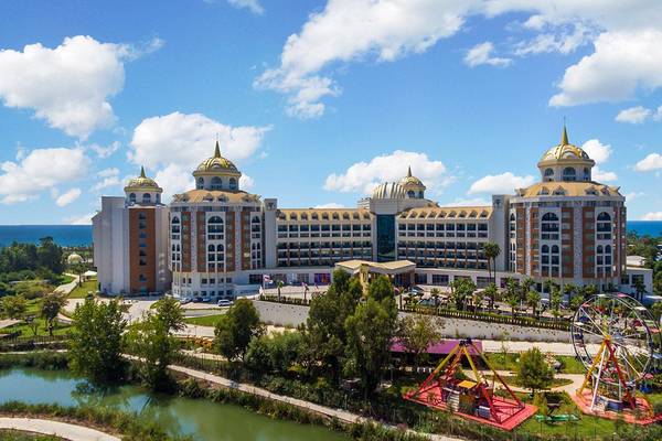 Luftaufnahme des Delphin BE Grand Resort mit Meer und Vergnügungspark im Vordergrund