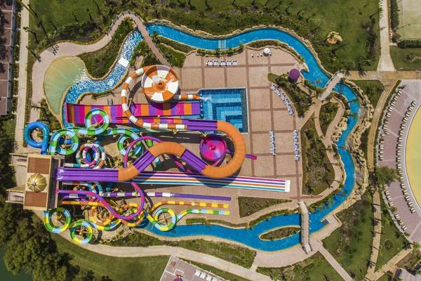 Luftaufnahme des Delphin BE Grand Resort Wasserparks mit bunten Rutschen und Pools.