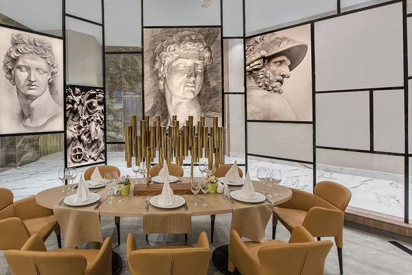Speisesaal im Delphin BE Grand Resort mit klassischen Kunstwerken an den Wänden und runden Tisch.