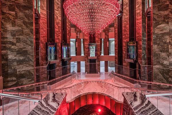 Lobby des Delphin BE Grand Resort mit einer großen roten Beleuchtung und Marmorwänden.