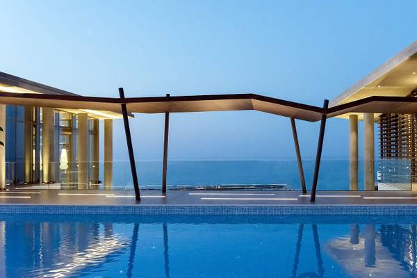 Außenpoolbereich des Nana Princess Suites Hotels mit Blick auf das Meer bei Nacht