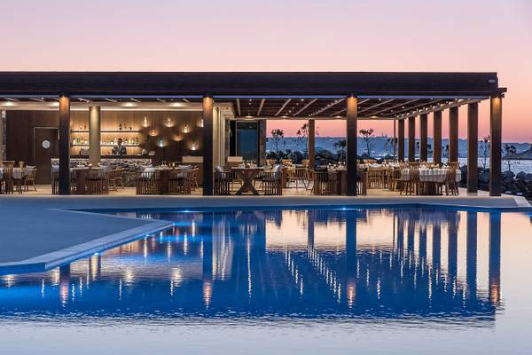Am Abend ist die Pool-Terrasse des Nana Princess Suites Hotels mit blauem Wasser und blauer Beleuchtung zu sehen.