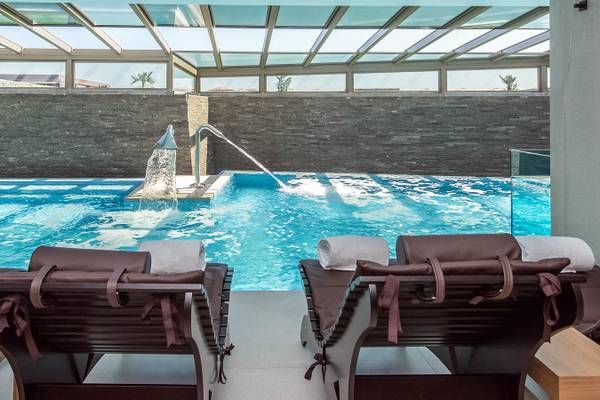 Innenpool der Nana Princess Suites mit zwei Lounge-Liegestühlen und Handtüchern.