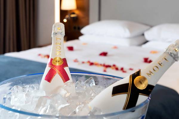 Zwei Flaschen Moet in einem Eiskühlbecken auf einem Bett mit Rosenblättern