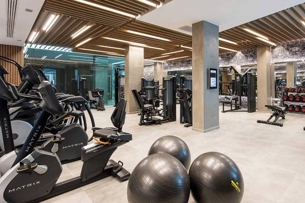Fitnesscenter im Nana Princess Suites Hotel mit verschiedenen Trainingsgeräten und Hanteln.