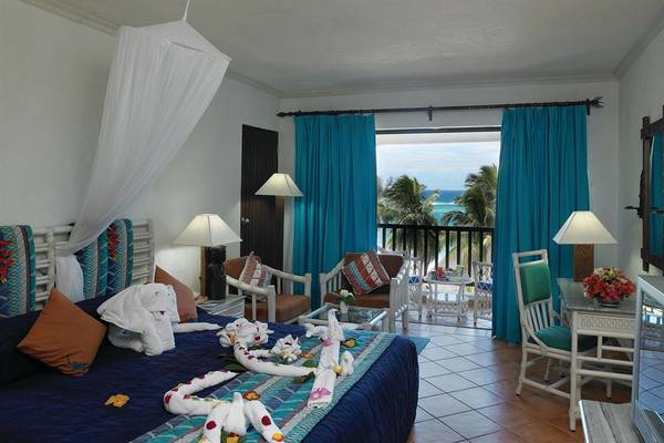 Innenansicht eines Zimmers im Diani Reef Beach Resort & Spa mit Blick auf den Ozean.