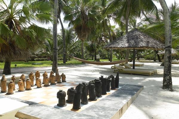 Im Garten des Diani Reef Beach Resort & Spa befindet sich ein Schachspiel auf einer Betonfläche.