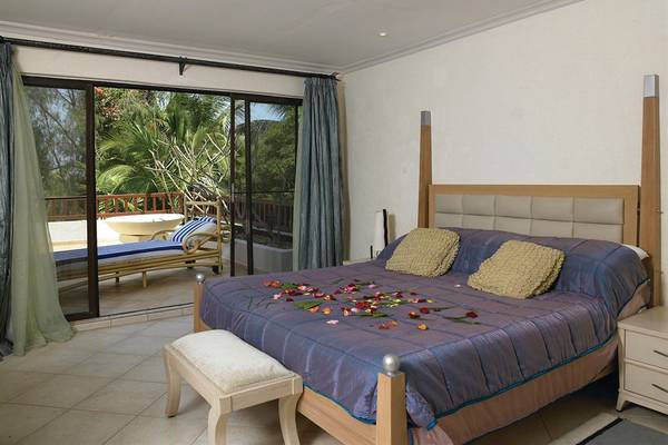 Schlafzimmer im Diani Reef Beach Resort & Spa mit Terrasse und Gartenblick.
