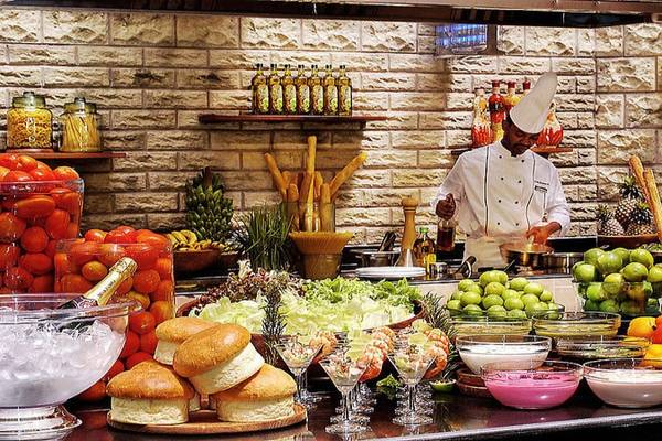 Buffet-Tisch im Diani Reef Beach Resort & Spa mit Salat, Obst und verschiedenen Gerichten.