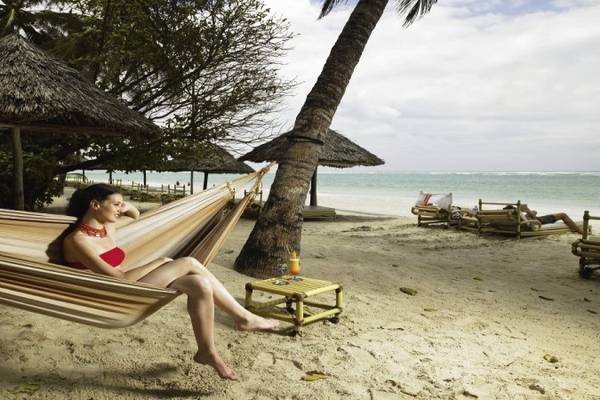 Frau im Hängematten am Strand des Diani Reef Beach Resort & Spa
