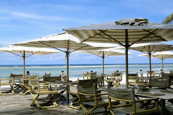 Sonnenschirme auf der Terrasse des Diani Reef Beach Resort & Spa mit Blick auf den Ozean