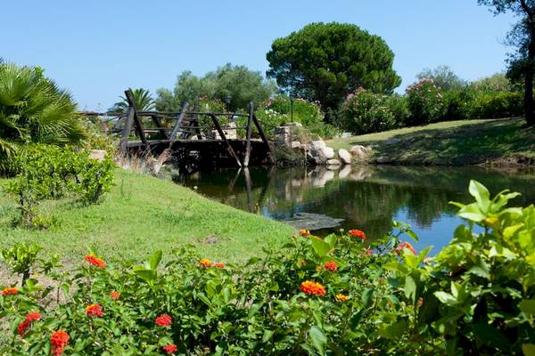 Garten des Bagaglino I Giardini di Porto Cervo Hotels mit Brücke über einem Teich