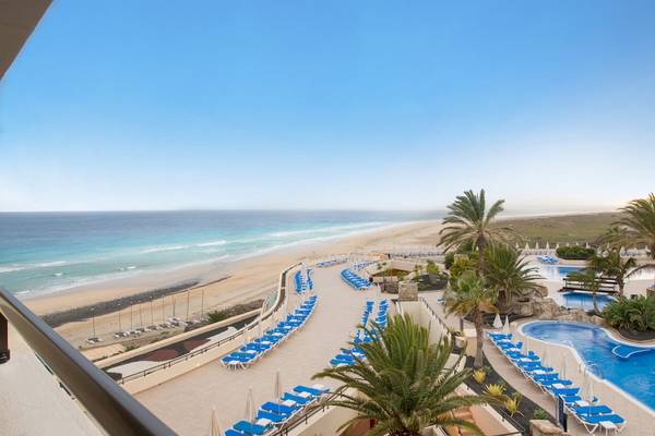 Ausblick auf den Strand und das Hotel Iberostar Playa Gaviotas Park mit blauem Pool und Sonnenliegen.