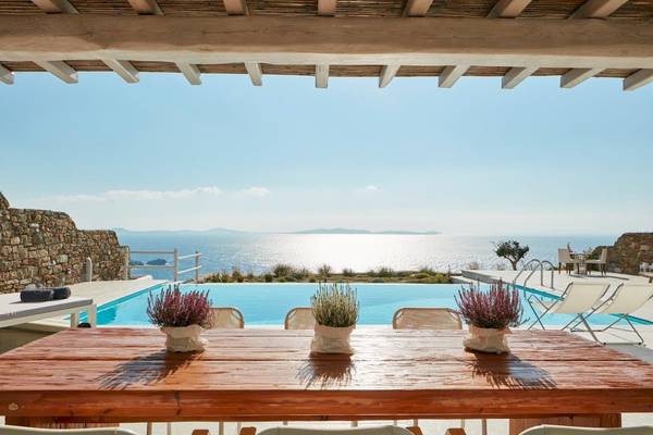 Aussicht auf den Pool im Mykonos Ammos Hotel mit Blick auf das Meer und die Landschaft.